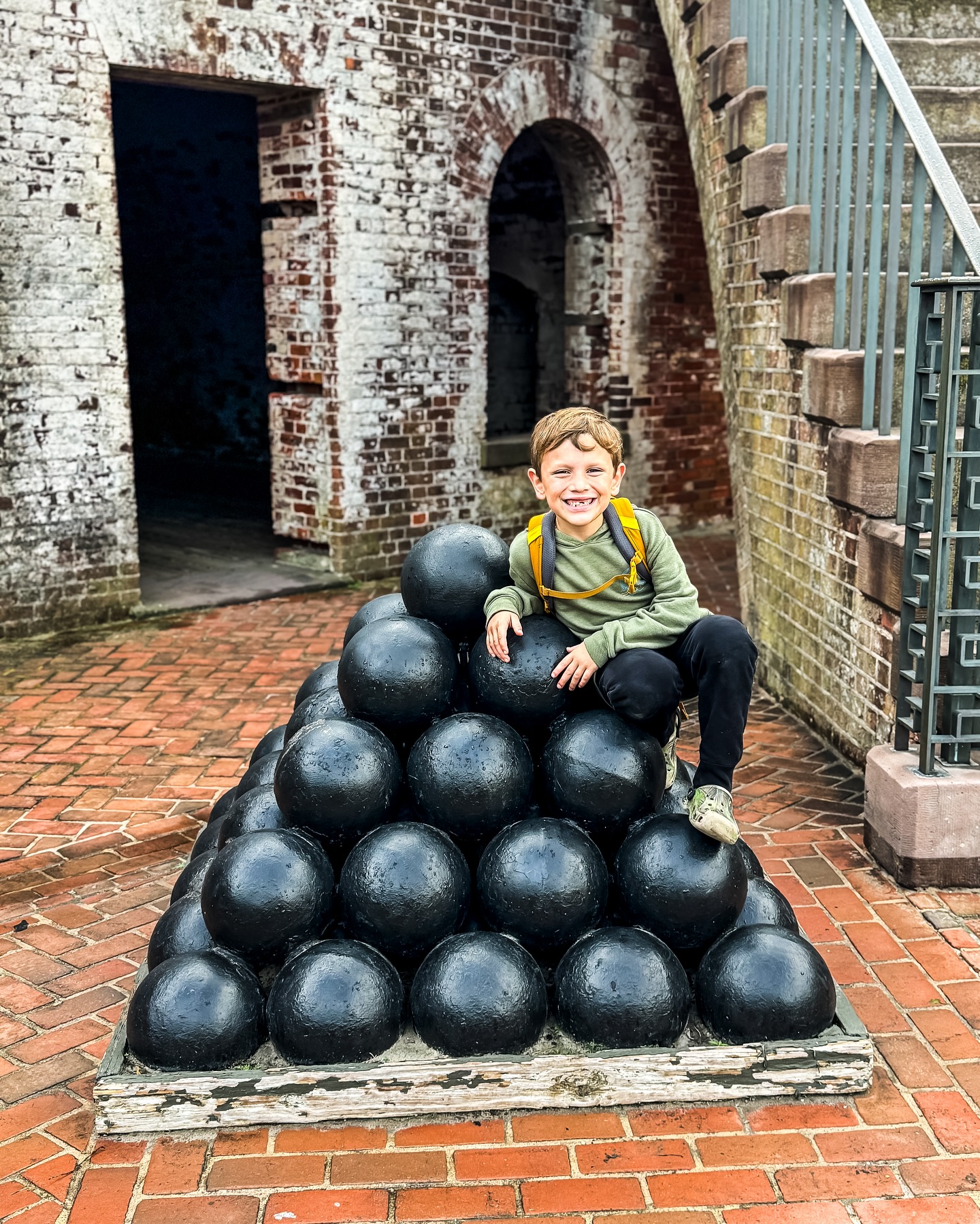 Kid on cannon balls at Fort Macon State Park