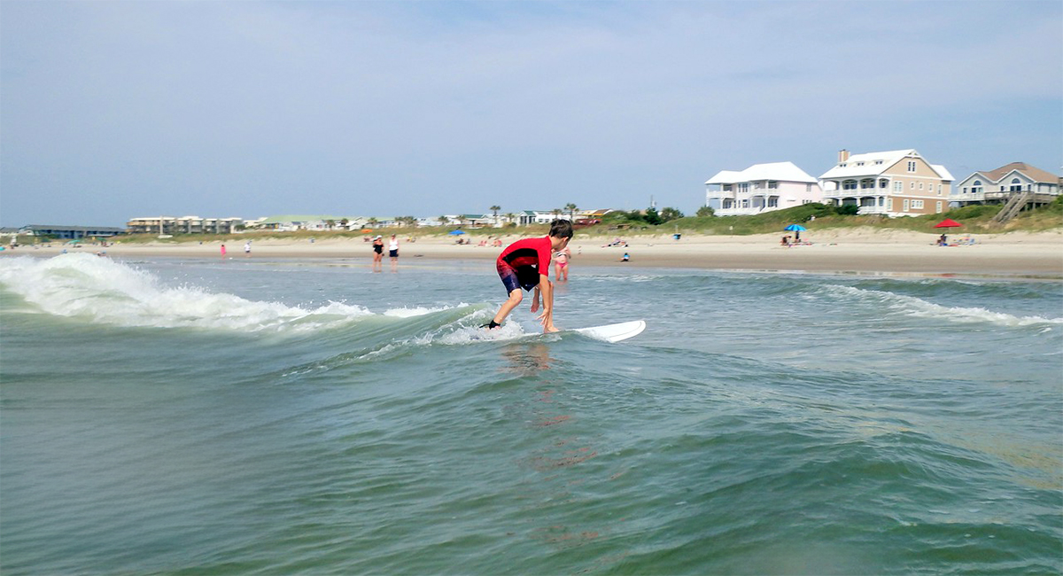 Kid surfing on Emerald Isle beaches