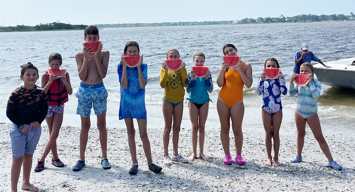 Kids eating watermelon and enjoying fresh market produce from the Crystal Coast