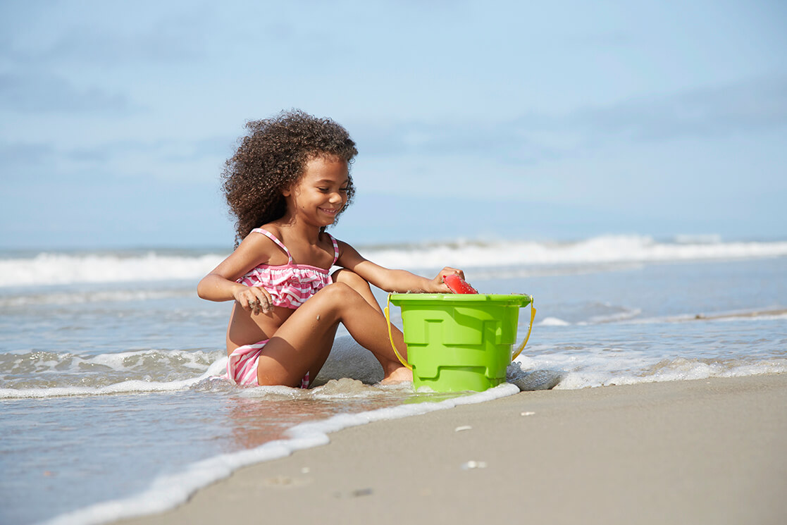 Girl playing in the sand on Emerald Isle beach